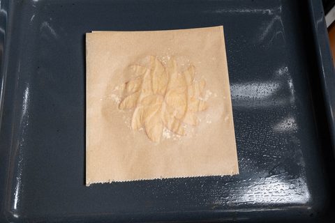 Apfelspalten auf Backpapier im Backofen