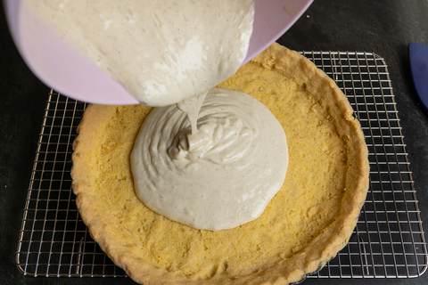 Cremefüllung wird in gebackenen Tarteboden gegossen