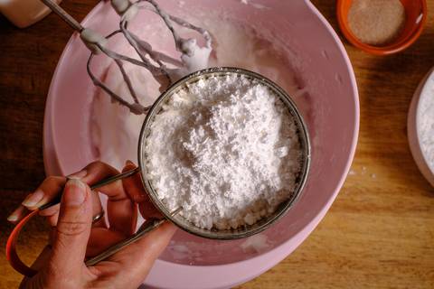 Puderzucker in den Eischnee sieben