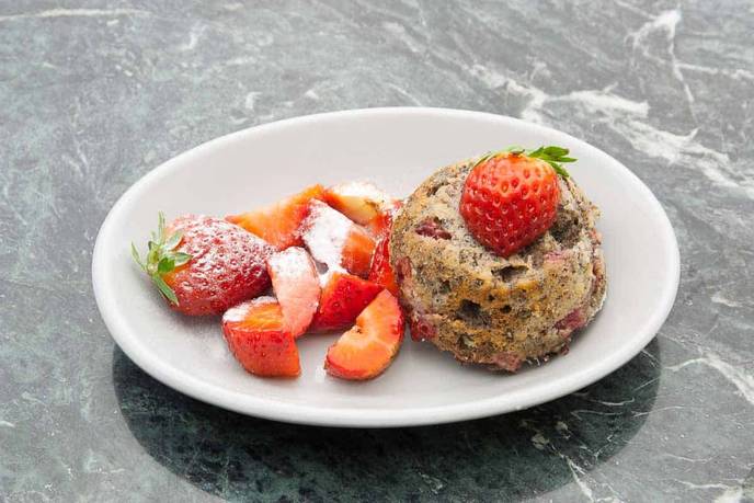 Erdbeer-Muffin frisch gebacken, angerichtet mit frischen Erdbeeren