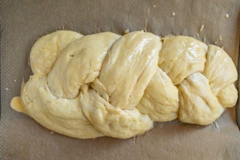 Hefezopf vor dem Backen mit Eigelb bestrichen