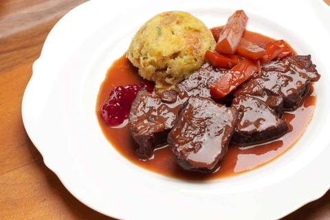 Hirschbraten mit Knödel als Souffle, geschmorten Karotten, Soße und Preiselbeeren