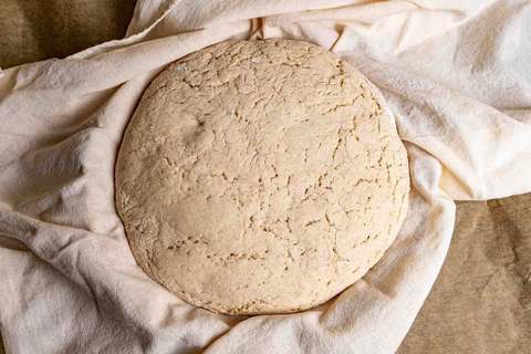 Kartoffelbrotteig im Gärkorb aufgegangen