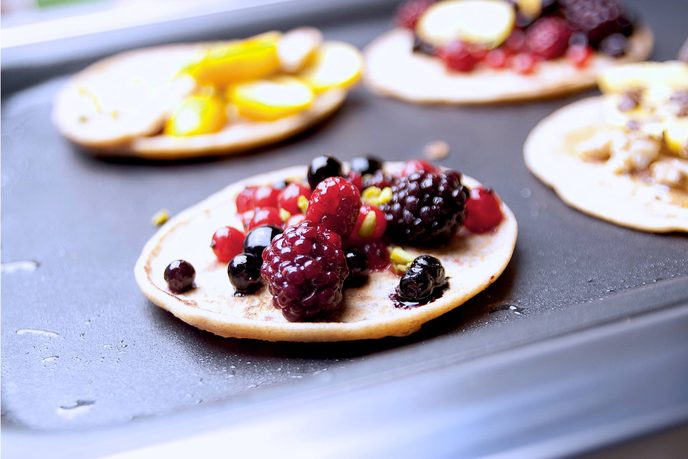 Pancakes mit Beeren und Blaubeeren auf dem Backblech