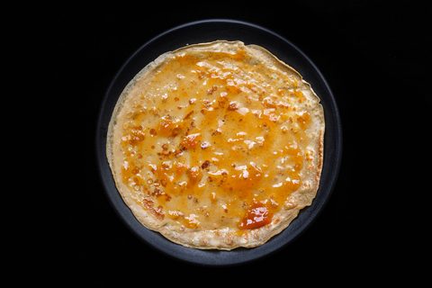 Pfannkuchen mit Marmelade bestrichen auf dem Teller