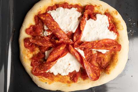 Pizza Diavola vorgebacken und belegt mit Salami Calabrese