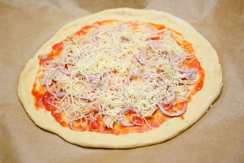 Käse auf die Thunfischpizza legen