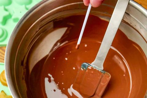 Stiele der Cake Pops in Schokolade tauchen