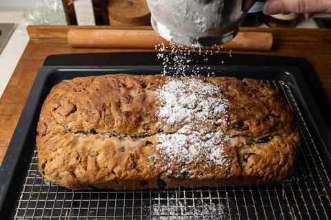 Gebutterten Stollen mit Puderzucker bestreuen