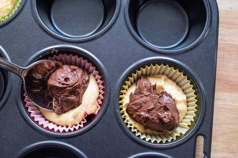 Dunklen Teig in die Muffinformen geben