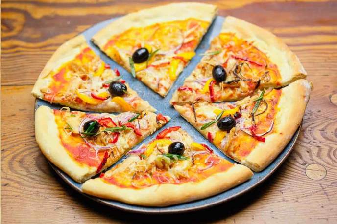 Thunfisch-Pizza in 6 Stücke geschnitten auf einem Pizzablech