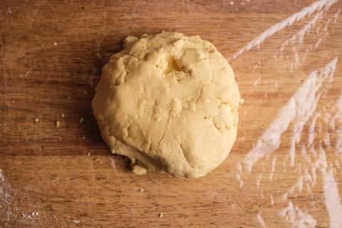 Zur Kugel geformter Vanillekipferlteig auf Frischhaltefolie