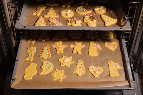 Weihnachtsplätzchen in den Ofen schieben