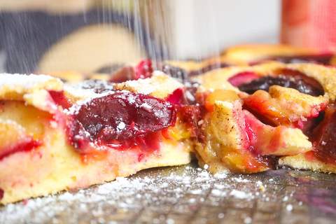 Zwetschgenkuchen mit Puderzucker bestreuen